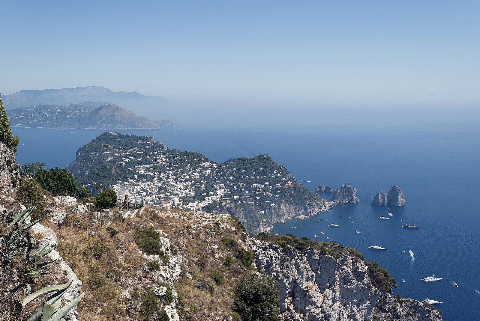 View over Capri from the heights above Anacapri, with the Faraglioni and the Sorrento peninsula beyond
