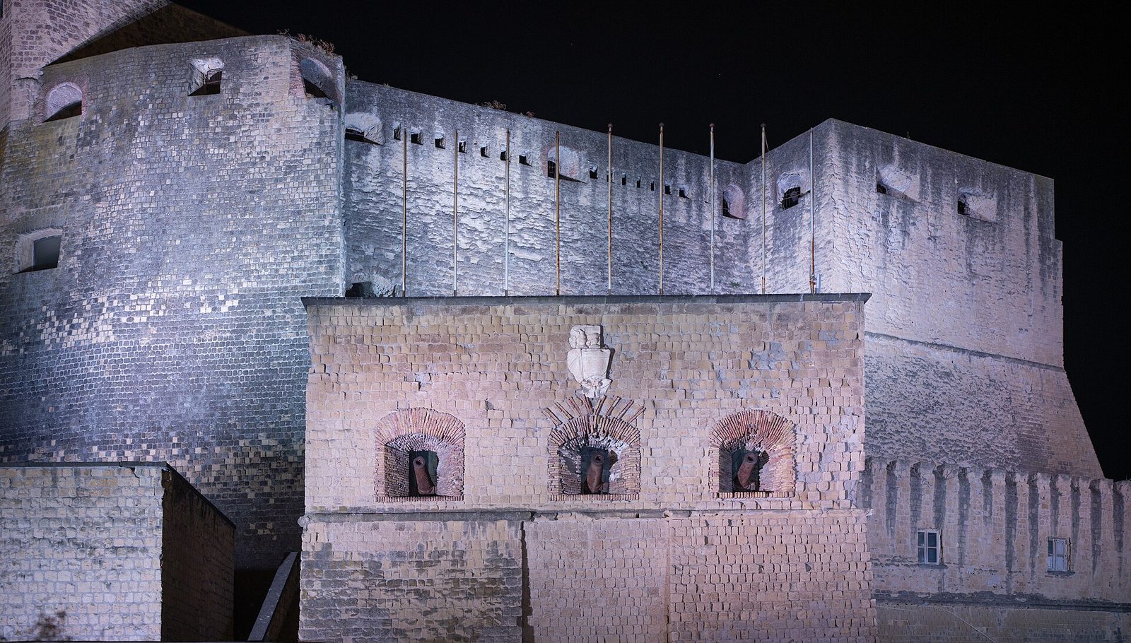 The walls of Castel dell'Ovo lit up at night on its islet off the Naples seafront