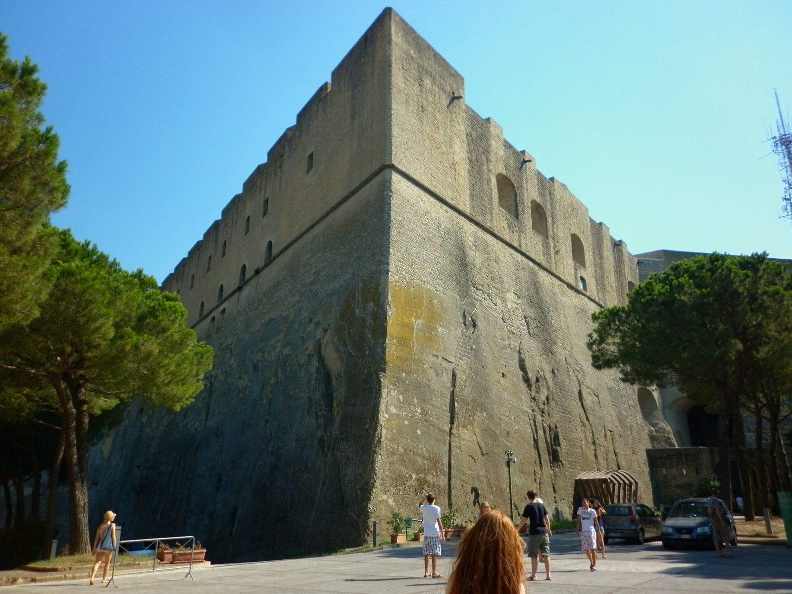 Naples castles: the massive stone walls of Castel Sant'Elmo on the Vomero hill, with visitors at the foot