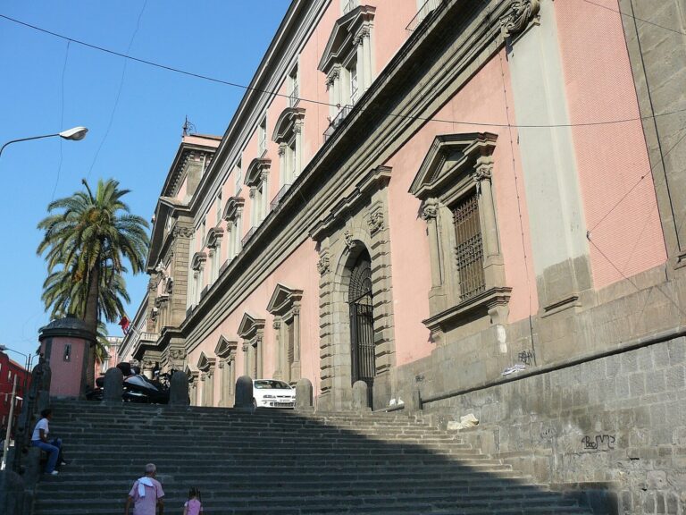 The red facade and entrance steps of the National Archaeological Museum of Naples