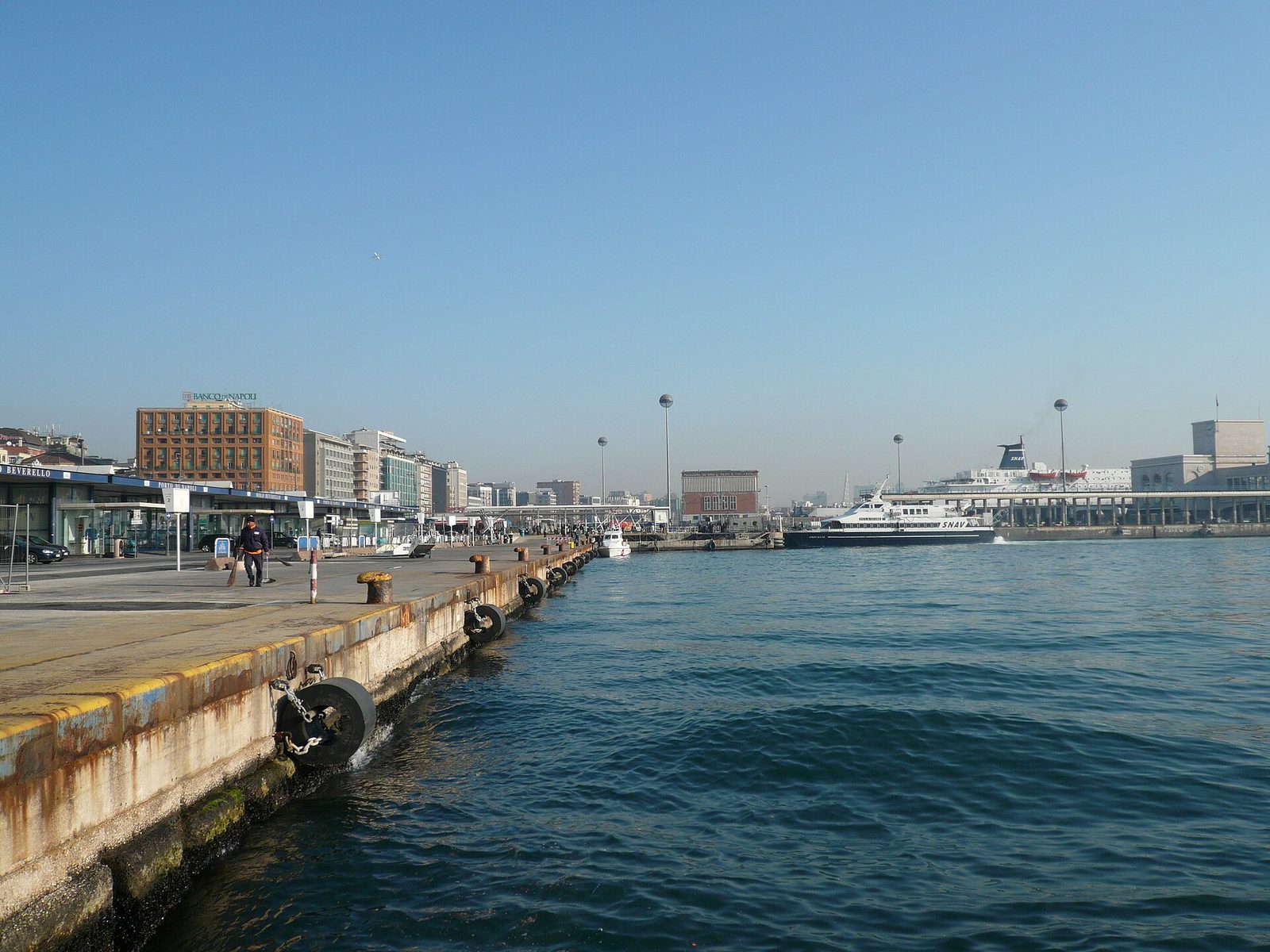 Naples ferry pier: the quay at Molo Beverello with the city waterfront and a fast ferry in the distance