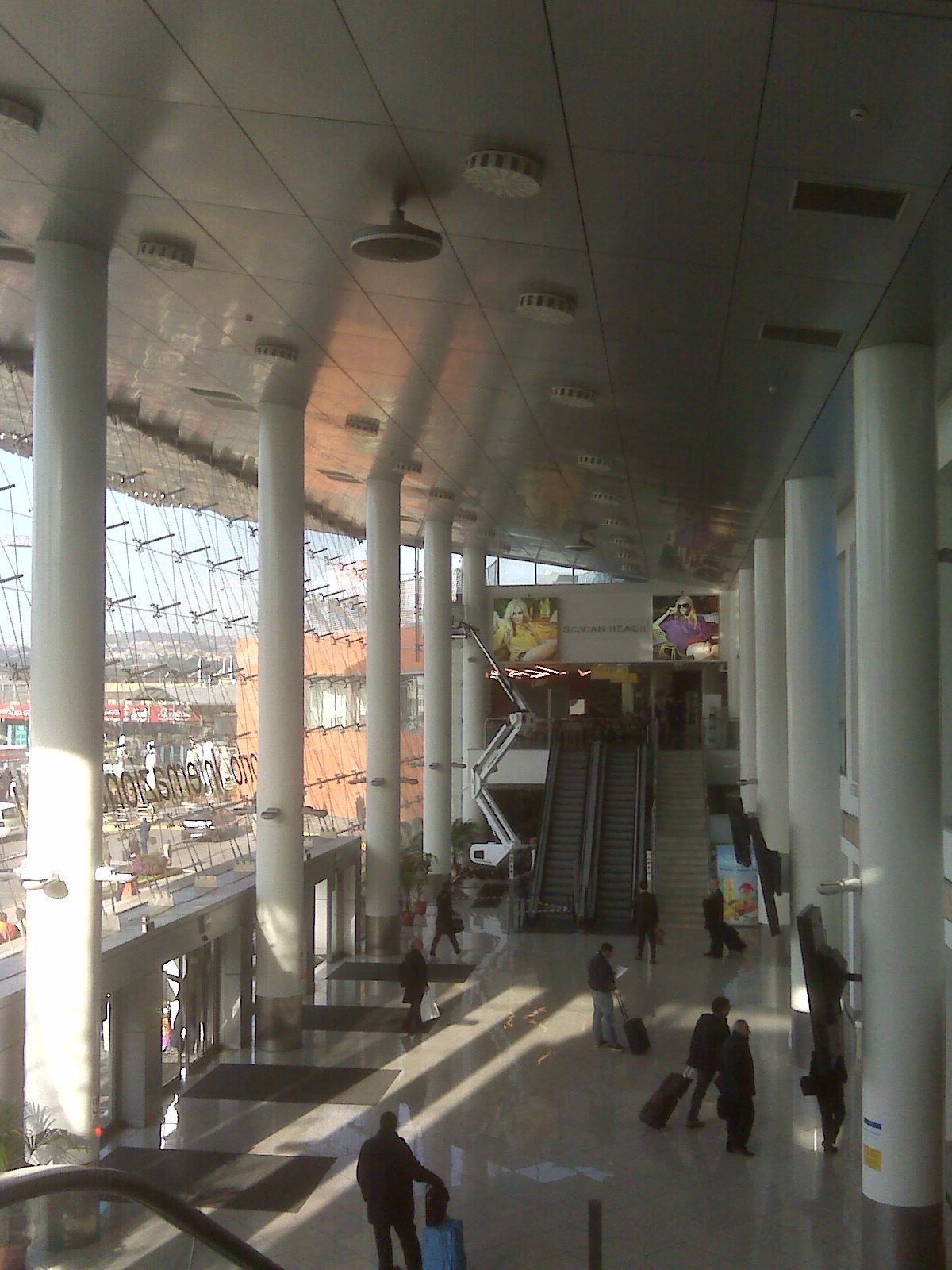 Naples airport to city center starts here: the bright main hall of Capodichino airport with travelers and luggage