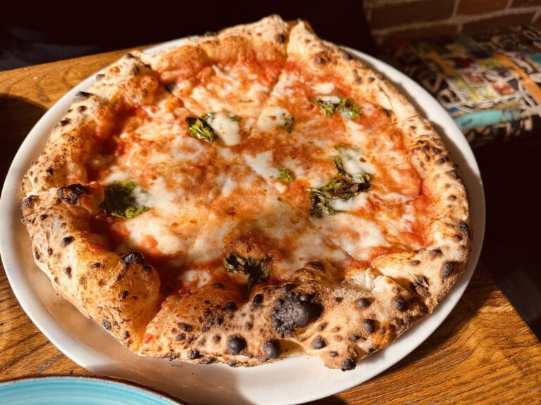 A Neapolitan-style margherita with a charred, puffy rim and a soft center