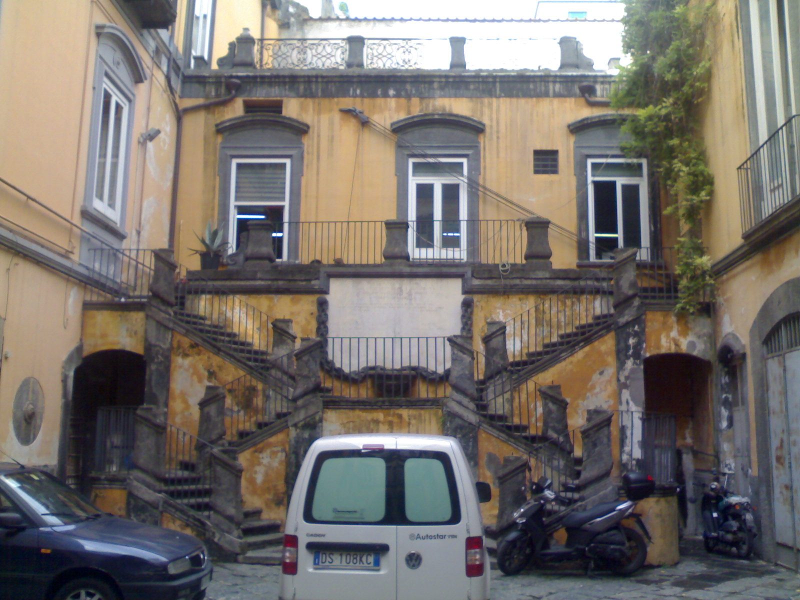 The courtyard and open double staircase of an old palazzo in the historic center of Naples