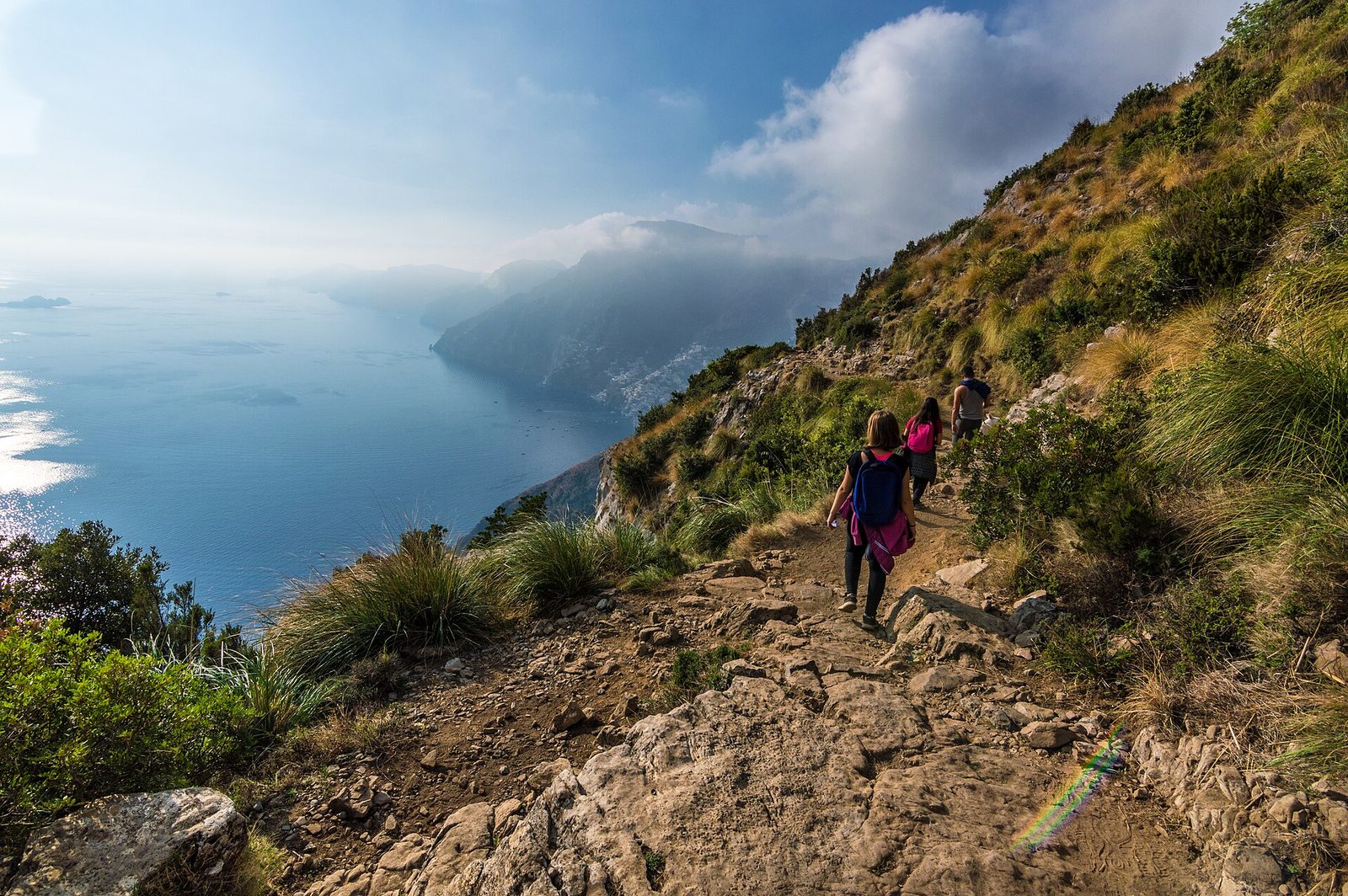 Hikers on the rocky Path of the Gods trail high above the Amalfi Coast
