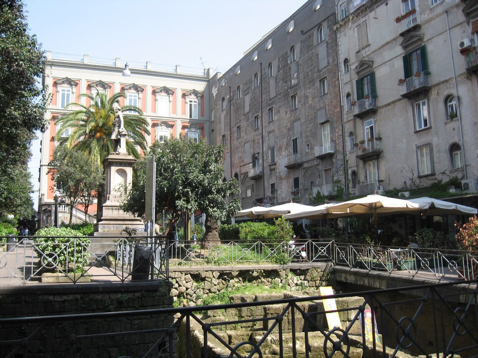 Piazza Bellini in the centro storico of Naples, with café tables around the excavated ancient Greek walls
