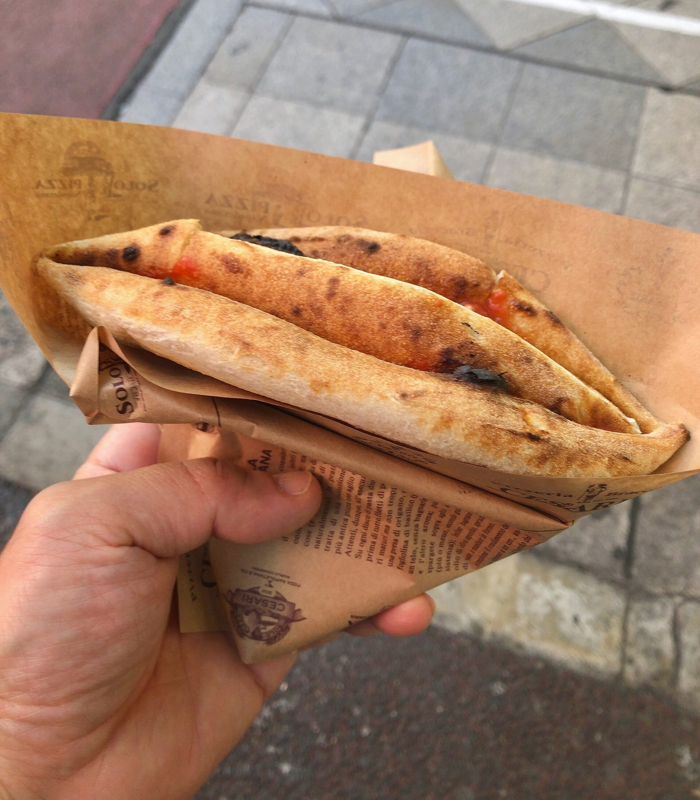Naples, Italy costs at their lowest: a pizza a portafoglio folded into quarters in paper