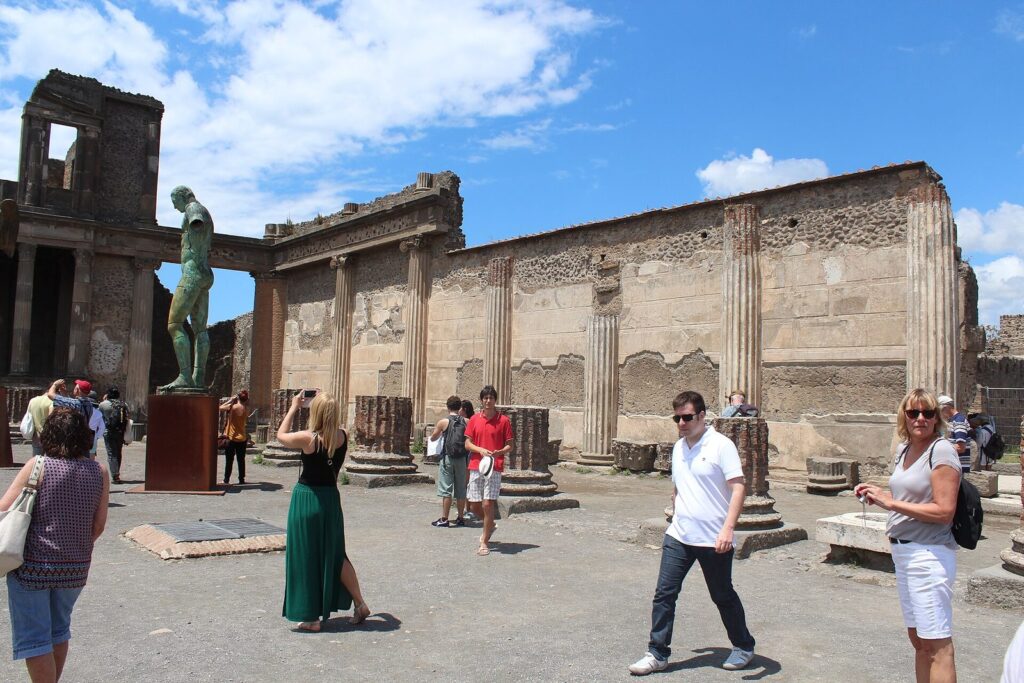Visitors exploring the ruins beside the Forum of Pompeii on a sunny day