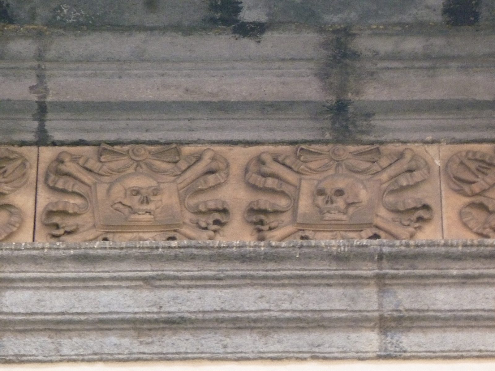 A carved frieze of skulls and crossbones on the facade of Santa Maria delle Anime del Purgatorio ad Arco on Via dei Tribunali