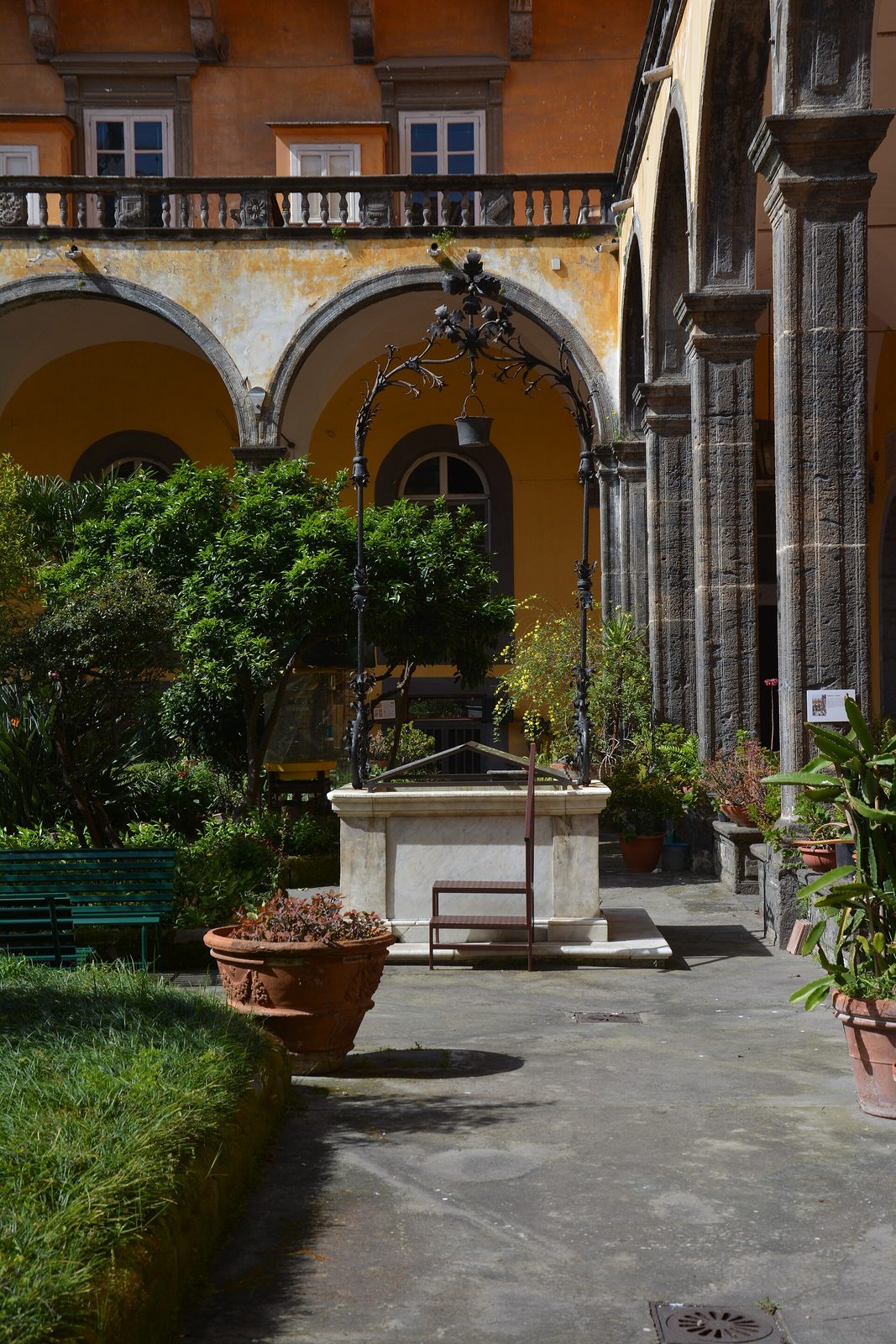 The cloister of San Gregorio Armeno with its well, plants and arcades in the Naples centro storico