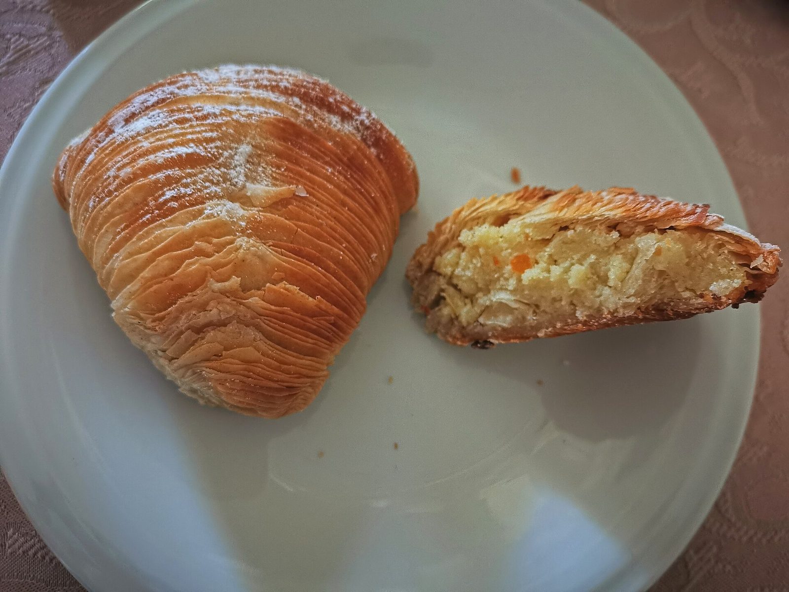 A sfogliatella riccia, the shell-shaped Neapolitan pastry, cut open to show its ricotta and candied peel filling
