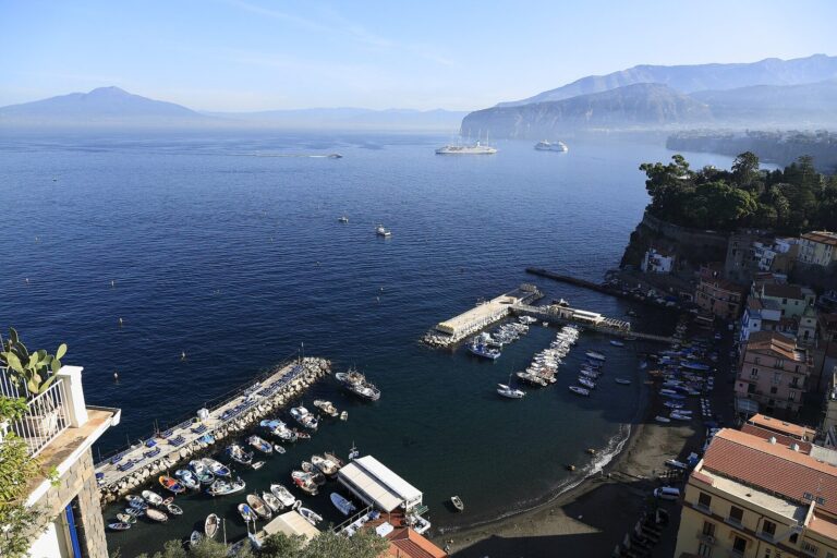 View from Sorrento's cliffs over a small marina and the Bay of Naples, with Vesuvius on the horizon