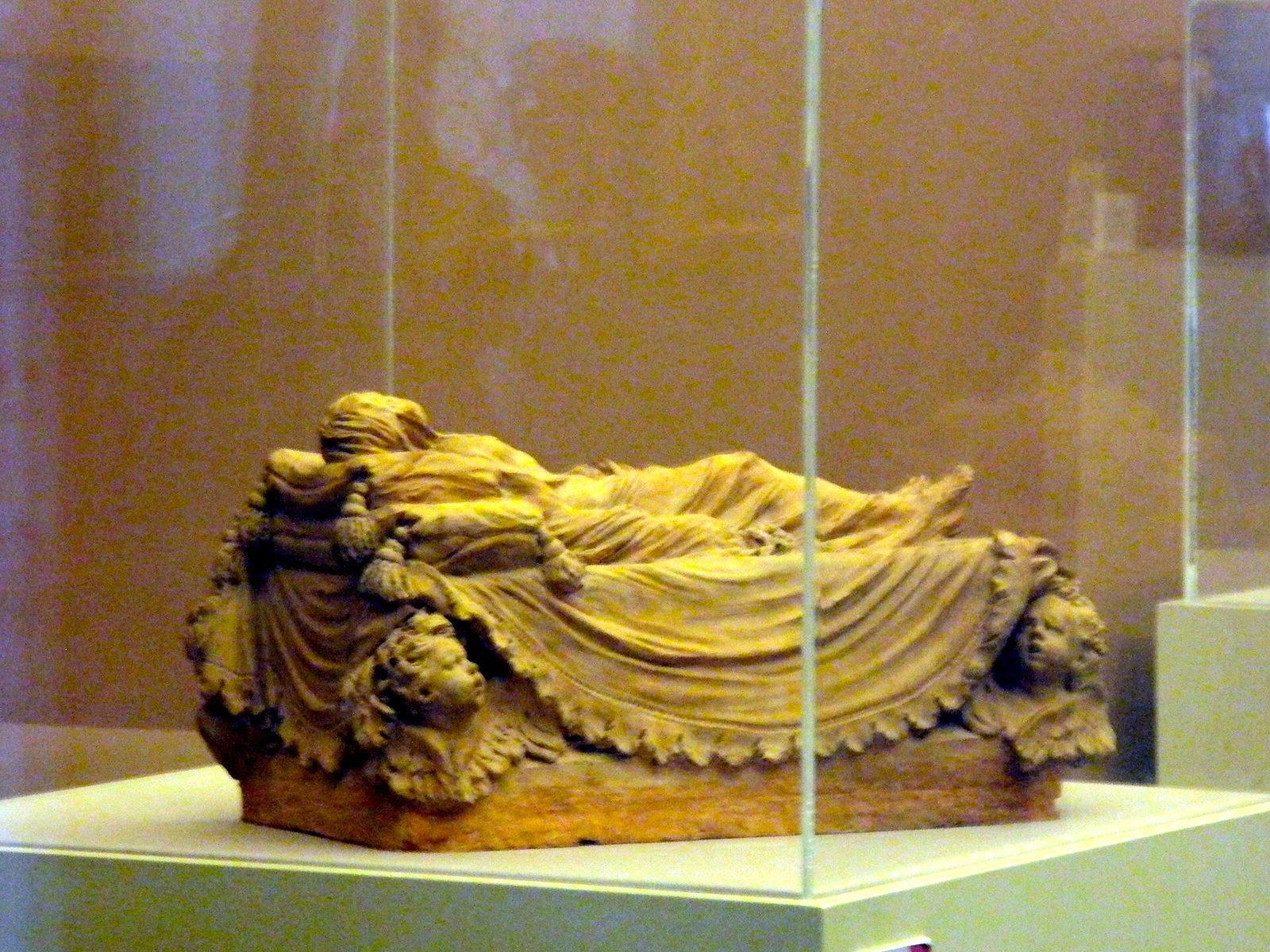A terracotta model of the Veiled Christ displayed in a glass case at the Certosa di San Martino in Naples