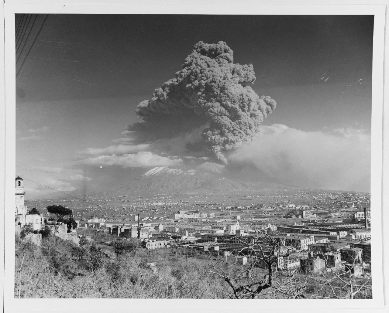 The eruption column of Mount Vesuvius rising above the towns around the bay during the March 1944 eruption