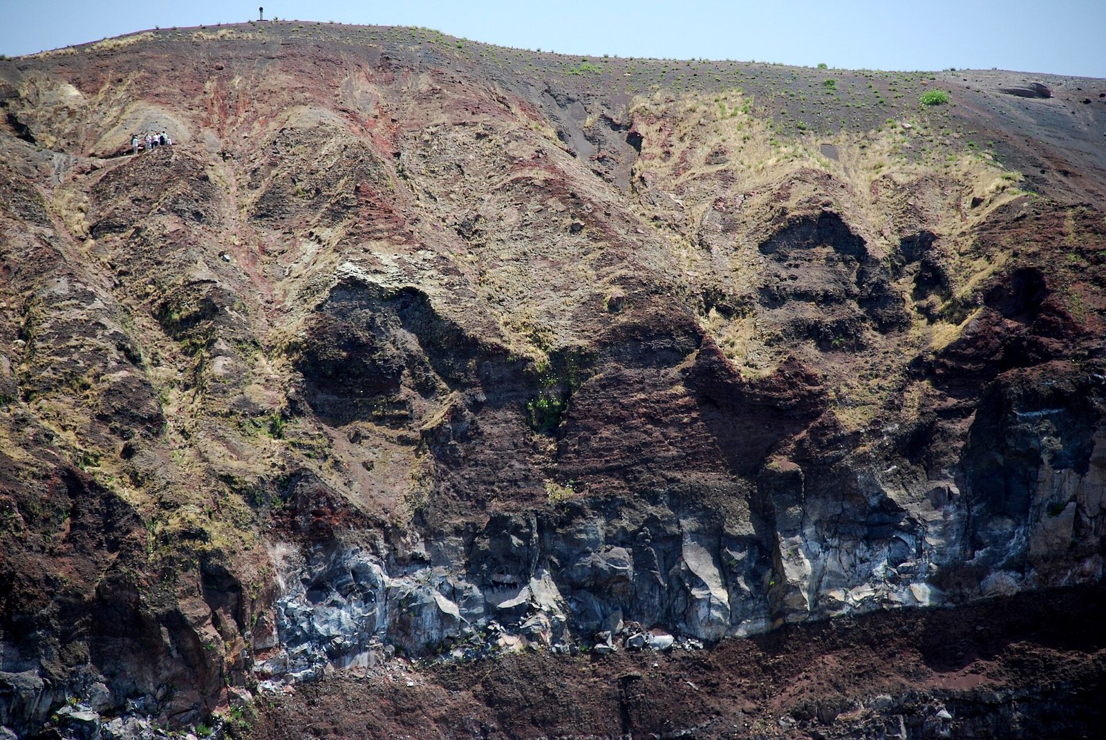 The layered red and gray walls of the Vesuvius crater seen from the rim path