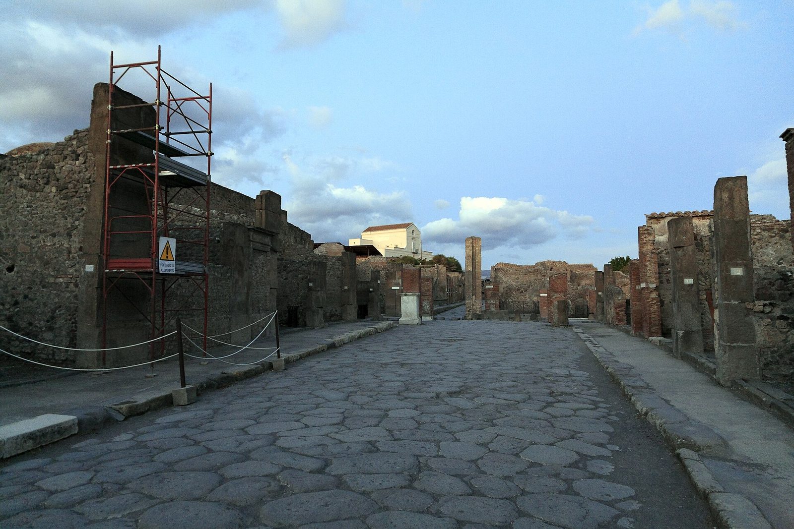 Via dell'Abbondanza in Pompeii, a long Roman street with basalt paving and ruined shopfronts