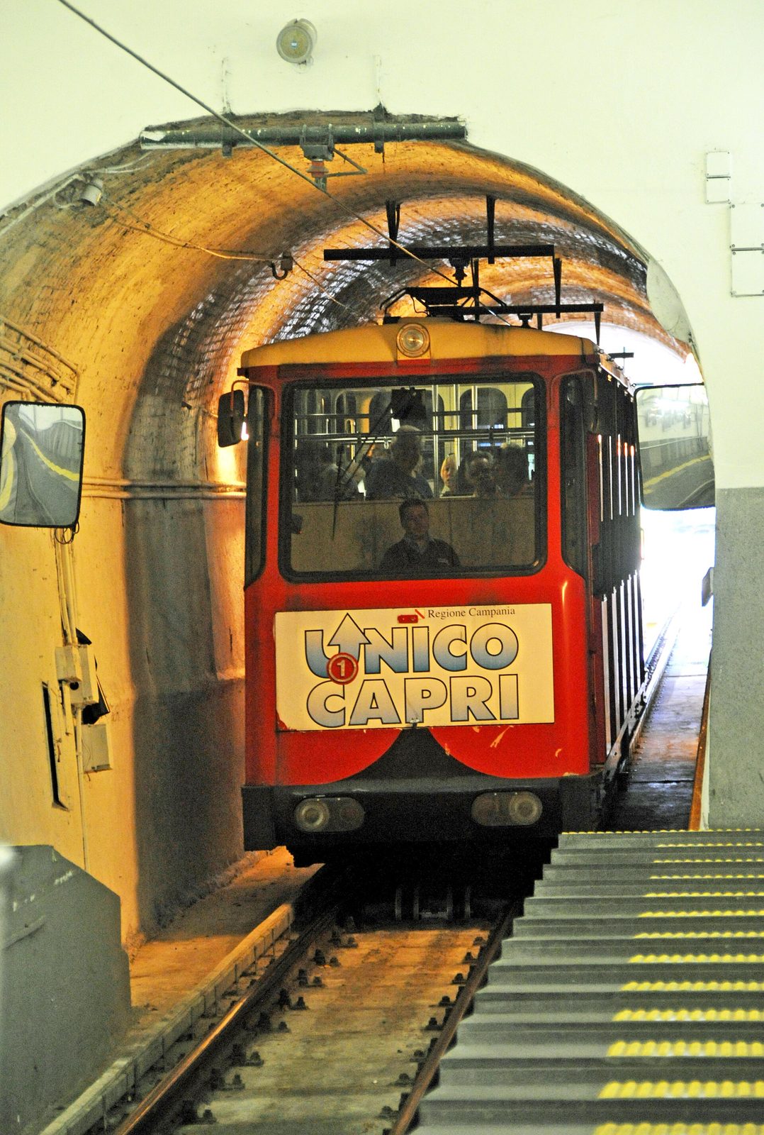 A red car of the Capri funicular arriving at the upper station