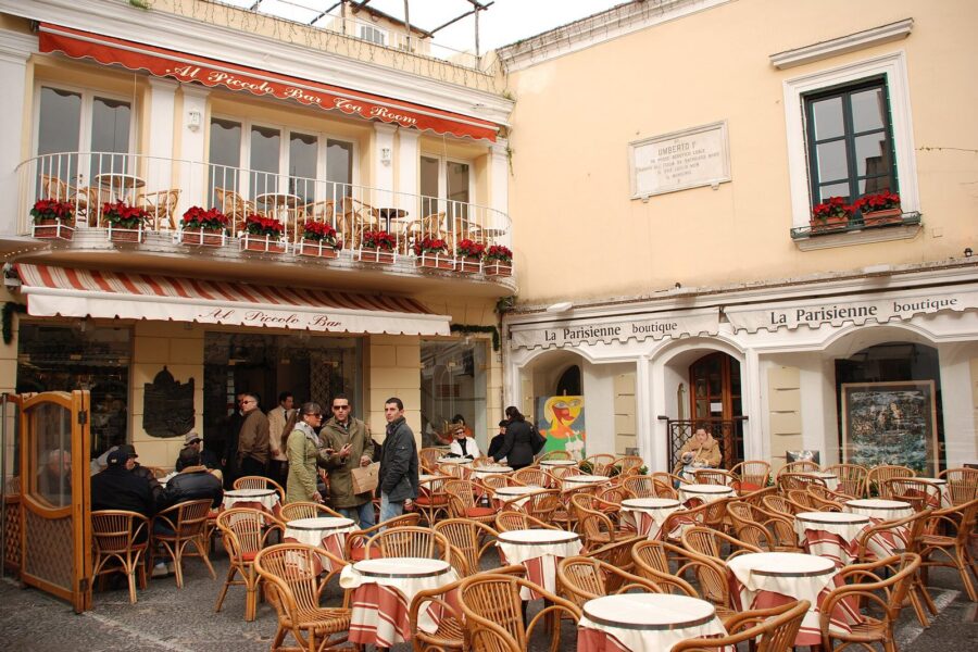 Café tables and people in coats outside a bar on the Piazzetta in Capri town