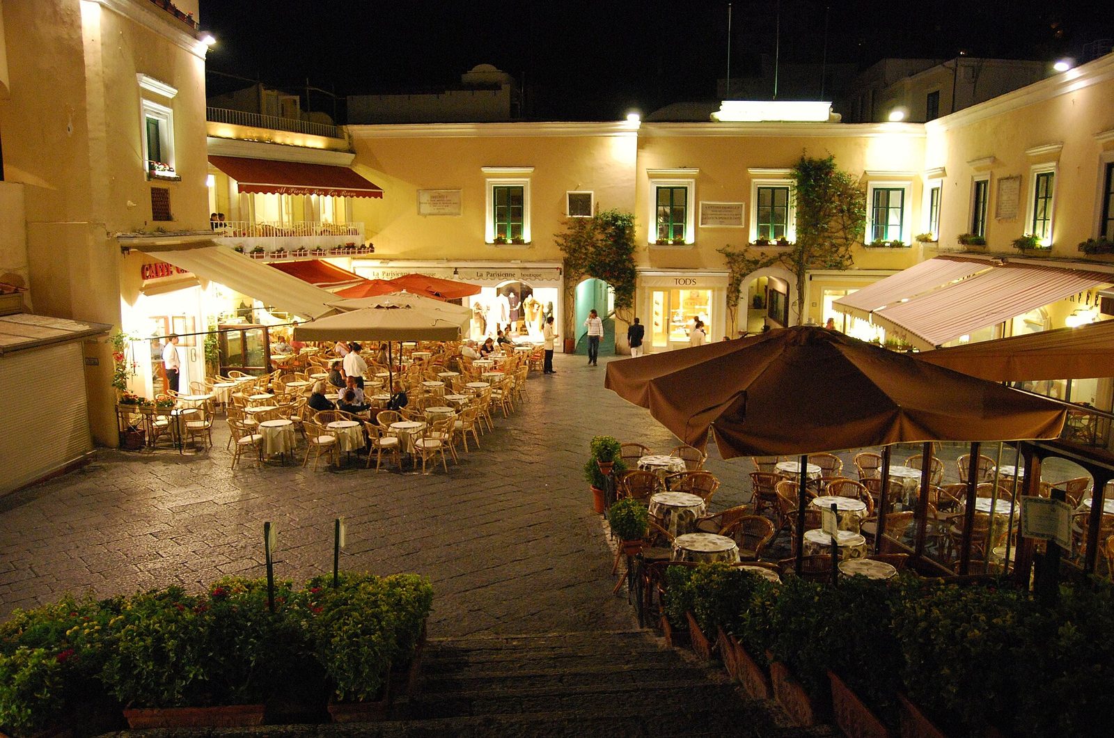 Café tables in the Piazzetta of Capri in the evening, under the lit terraces