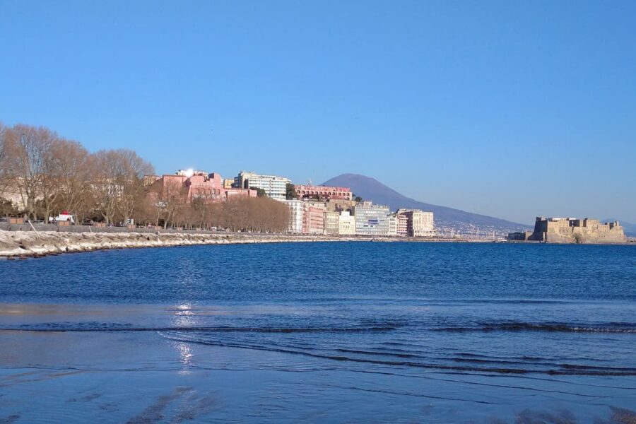 The Naples seafront with bare trees, Castel dell'Ovo and Vesuvius under a clear blue sky